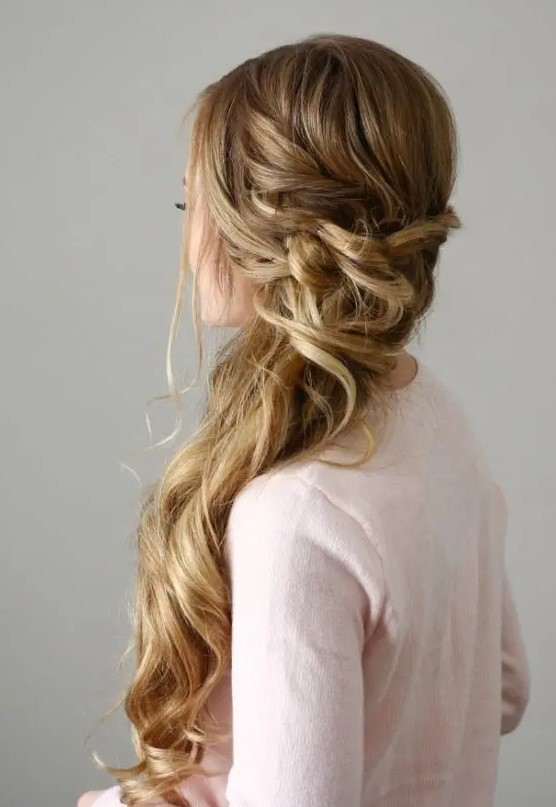 a beautiful side-swept Dutch braid with a twisted and wrapped touch and waves down plus face-framing hair