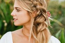 a beautiufl and romantic side braid into a ponytail, with face-framing waves is a stylish idea, accent it with fresh blooms