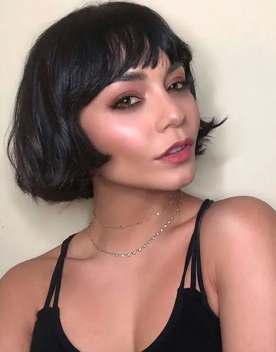 a black ear length bob with wispy bangs and wavy hair is a catchy and chic idea for a modern look