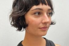 a black shaggy ear-length bob with wispy bangs is a cool solution, it looks messy and effortlessly chic