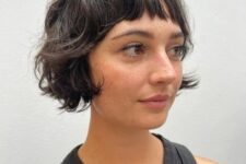 a black shaggy ear-length bob with wispy bangs is a cool solution, it looks messy and effortlessly chic