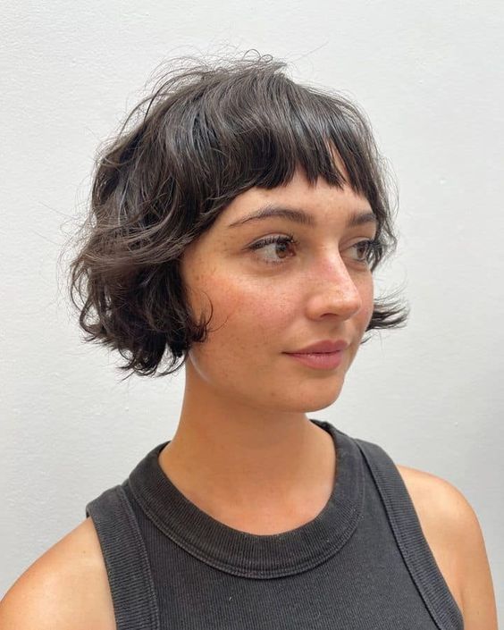 a black shaggy ear length bob with wispy bangs is a cool solution, it looks messy and effortlessly chic