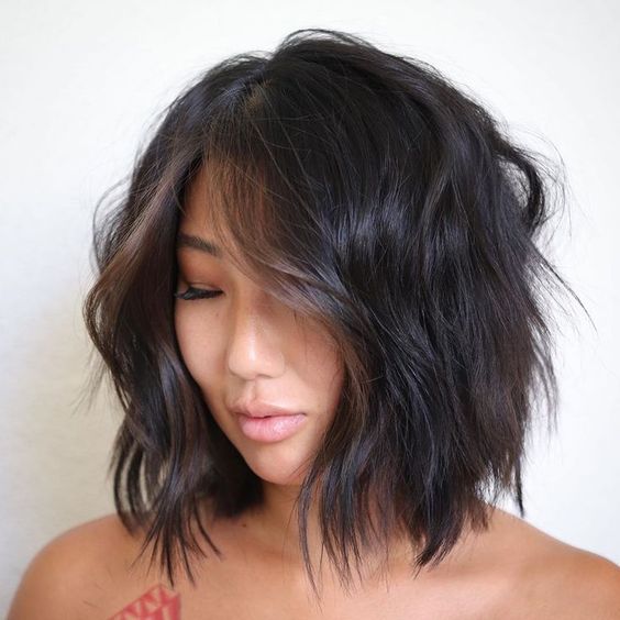 a black shaggy long bob with messy waves and chestnut money piece is a chic and lovely idea to rock
