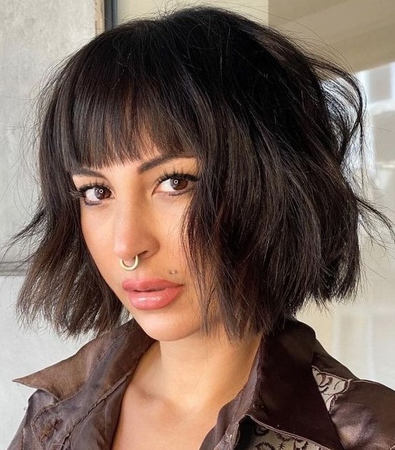 a black textural and wavy chin length bob with waves and blunt bangs is a stylish and catchy idea