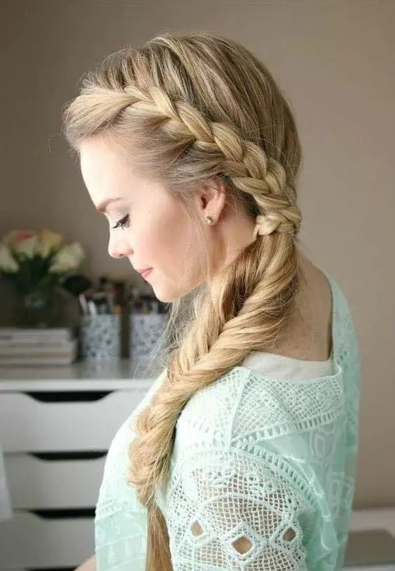 a boho side swept hairstyle of a braid coming down is a stylish idea for a boho or rustic bride
