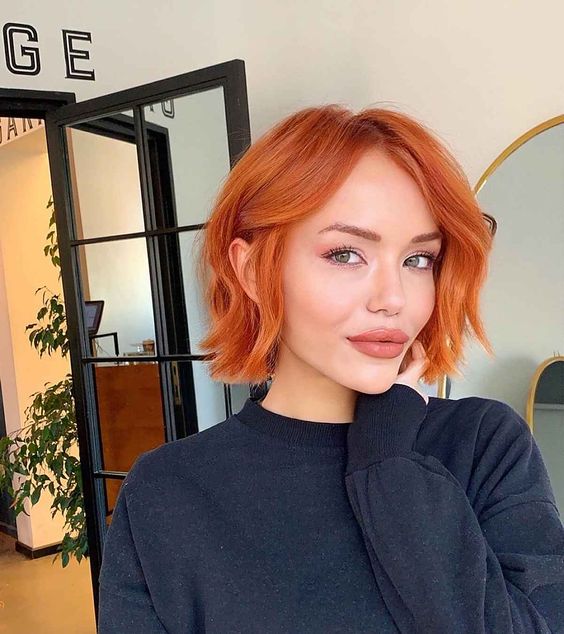 a bold copper red chin length bob with a bit of waves is a stylish idea that will catch an eye with color