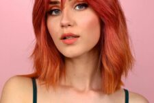 a bold textural and dimensional red long bob with an ombre effect, from burgundy to hot red and copper red