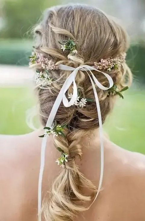 a braid with some curls and some blooms and greenery plus a thin ribbon is a great solution for a spring or summer wedding