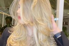 a bright and catchy blonde butterfly haircut with wavy ends and a lot of volume is a stunning idea for anyone