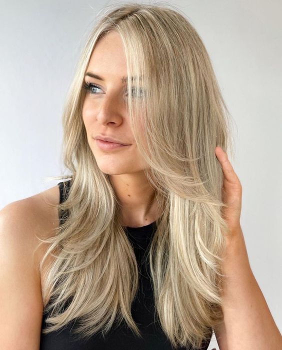 A bright blonde butterfly haircut with curved ends is a lovely idea for a chic and beach inspired look