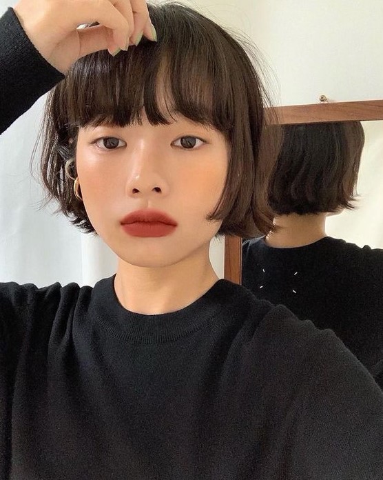 a brunette ear length bob with outgrown bangs and messy texture is a lovely idea