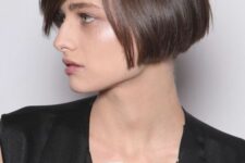 a brunette ear-length bob with side parting, with a sleek finish is a catchy and stylish idea for a modern look