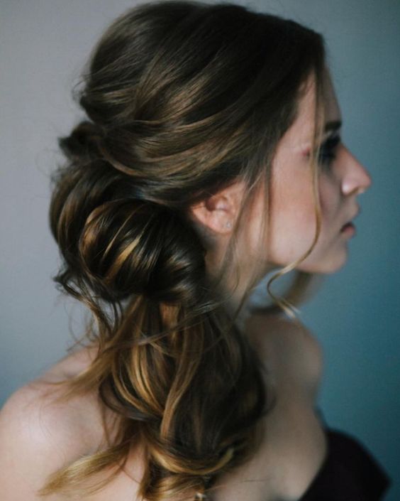 a catchy wrapped and twisted side ponytail with a bump on top and some waves is a chic and refined idea to try