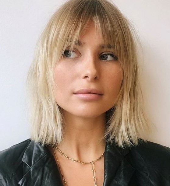 a chic long blonde bob with a darker root and curtain and bottleneck bangs is a catchy 70s inspired solution