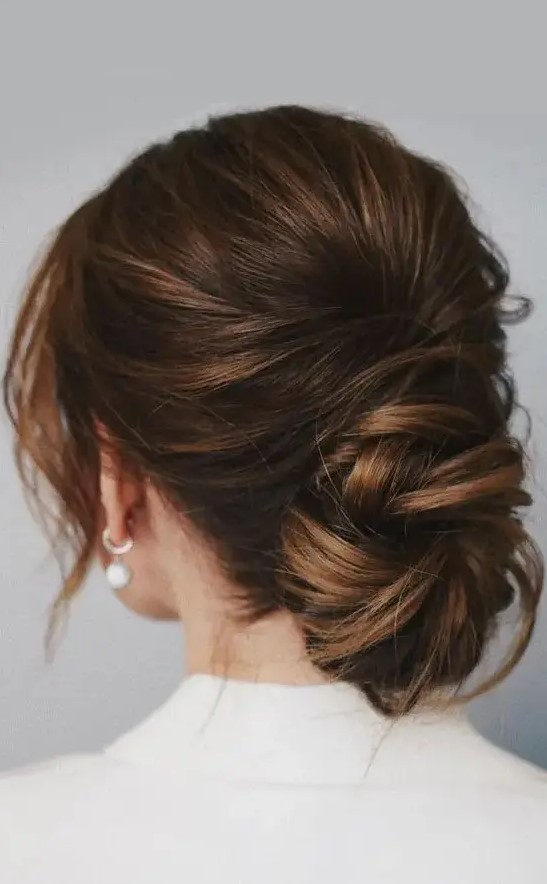 A chic low ballerina bun with a bump on top and face framing locks is a cool idea for a wedding