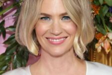 a chin-length blonde bob with a darker root and messy parting, with waves is a stylish idea, it looks gentle and chic
