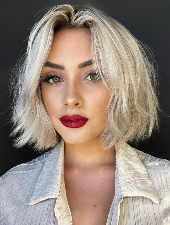 a chin length icy blonde bob with a darker root and a lot of volume is a catchy and bold solution