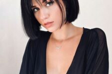 a classy black chin-length bob with wispy bangs is a super modern and catchy idea to rock right now
