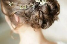 a classy curled low bun with a sleek volume on top and some waves down plus some fresh blooms is amazing