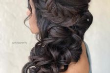 a curly side half updo with a braided halo and curls down is a lovely and chic solution for a wedding, it looks gorgeous