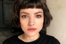 a dark brunette ear-length bob with baby bangs and waves is a cool idea for a modern and girlish look