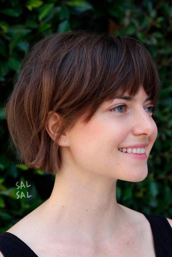 a dark brunette jaw length bob with caramel balayage and layered bangs is a catchy idea to rock right now