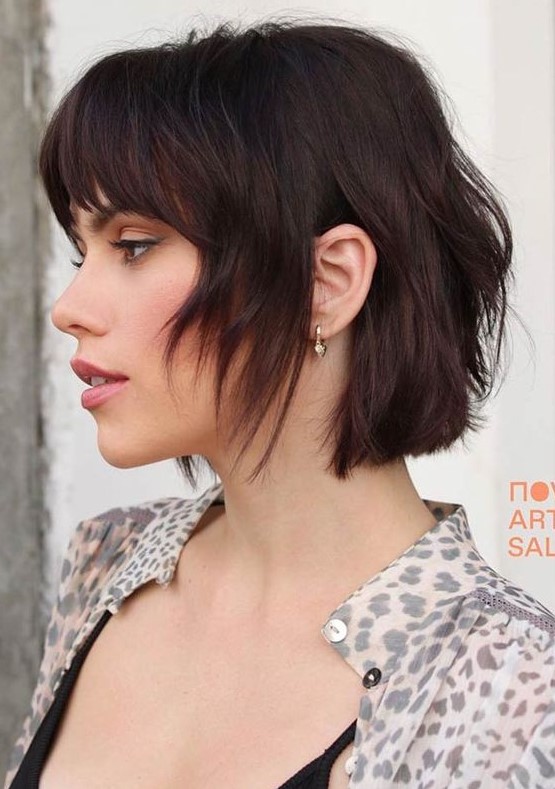 a dark chestnut shaggy and layered short bob with bottleneck bangs is a bold and catchy idea