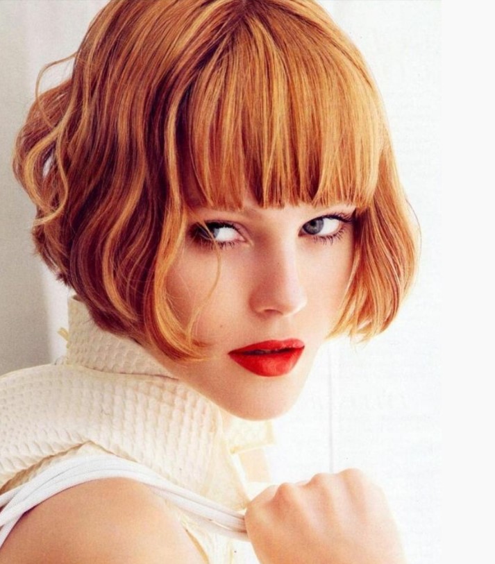 a ginger ear length bob with a thick classic fringe and waves is a super bold and eye catching idea that wows