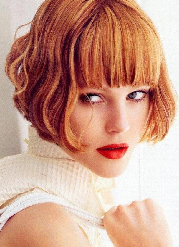 a ginger red ear length bob with a thick classic fringe and waves is a super bold and eye catching idea that wows