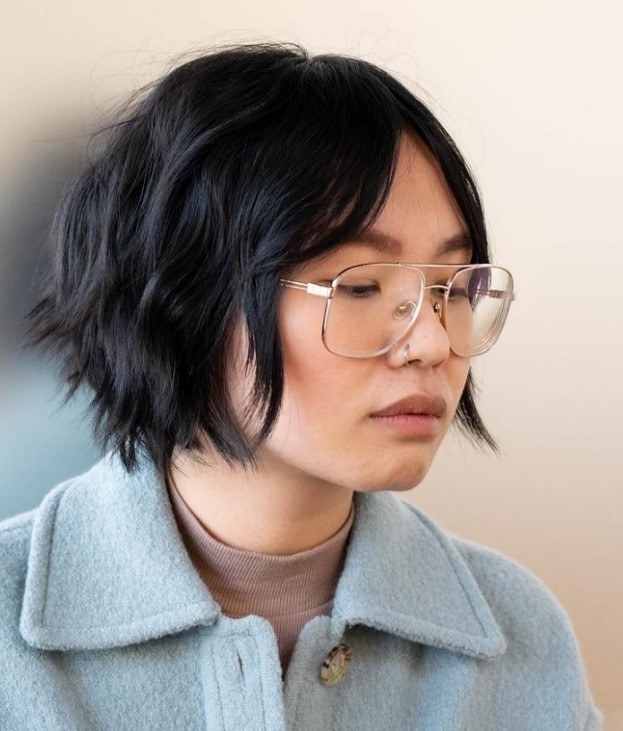 a graduated bob haircut in black, with curtain bangs is a very cool and chic idea to try right now