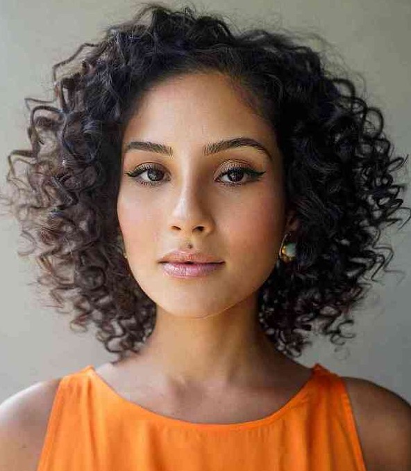 a layered curly bob in dark brown and almost black, with a messy part is a very lilvely and vivacious idea