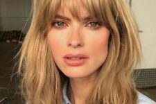 a layered honey bronde long bob with shaggy locks and with overgrown and very natural bangs is inspired by the 70s