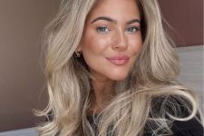 a long and fluffy blonde butterfly haircut with balayage, with curled ends and a lot of volume is a catchy and chic idea