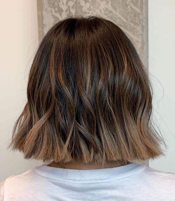 a long brunette bob with caramel balayage and waves is a chic and stylish idea to try right now
