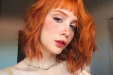 a long wavy ginger red bob with a classic fringe is a cool and bright solution that makes a statement with color
