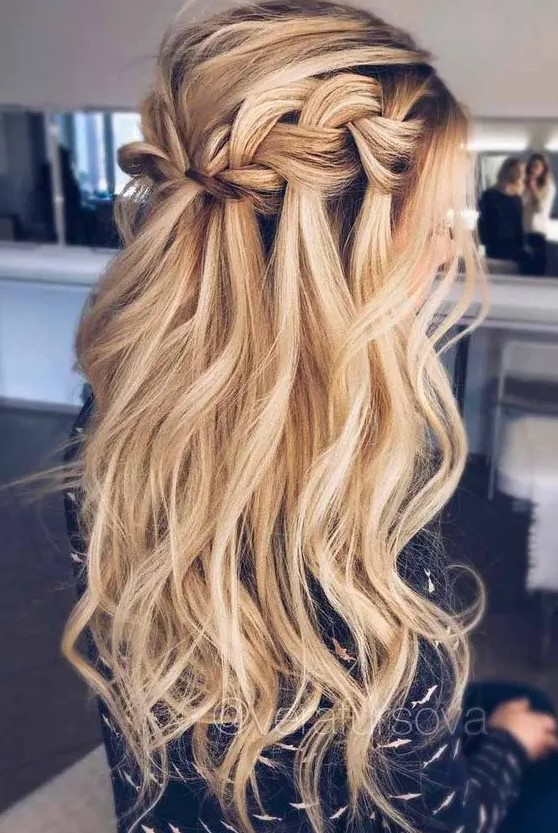 a long wavy half updo hairstyle with a braided halo and locks down for a boho feel