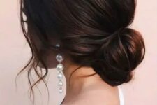 a loose low bun with a volume on top and some wavy locks down is a chic and beautiful idea for a modern bride