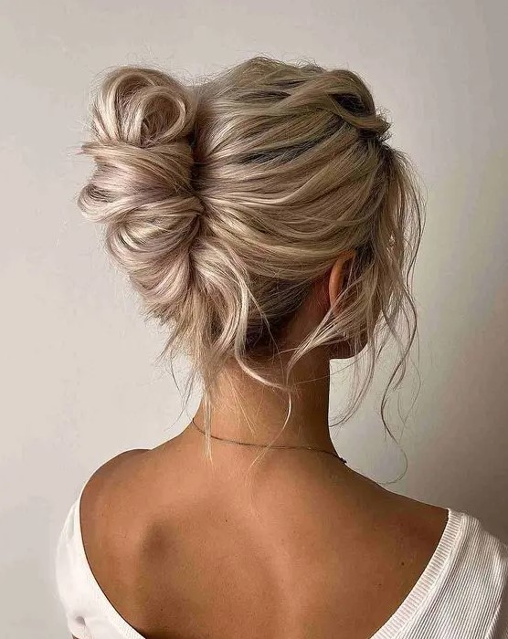 a lovely messy and twisted chignon hairstyle with a messy wavy top and some locks down is a lovely idea