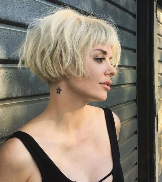 a lovely short blonde messy ear length bob with a classic fringe and dimension looks very grunge like