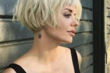 a lovely short blonde messy ear-length bob with a classic fringe and dimension looks very grunge-like