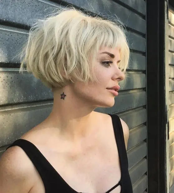 a lovely short blonde messy ear length bob with a classic fringe and dimension looks very grunge like