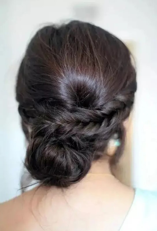 a low bun with a side braid and a bump for a whimsy take on a usual low bun hairstyle