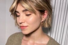 a messy and shaggy jaw-length bob with blonde balayage and short curtain bangs plus waves is a very fresh solution