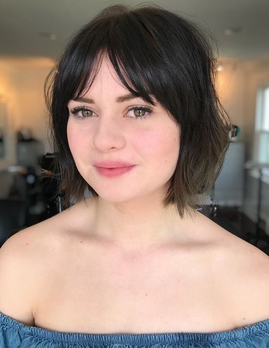 a messy and textural brown bob with layered and bottleneck bangs is a pretty and chic idea