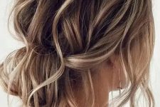 a messy wavy low bun with a messy wavy top and some locks down is a cool and lovely idea for a wedding, it looks effortlessly chic