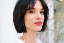 a midi black bob with curtain bangs and a bit of volume is a stylish idea for every type of hair