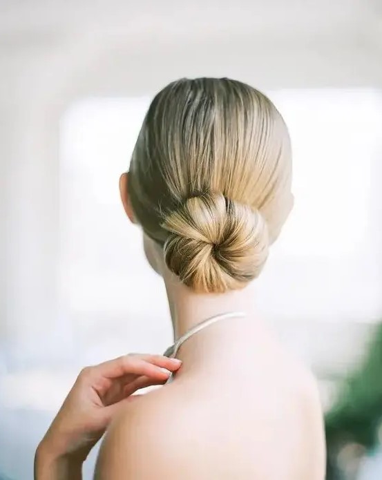 a minimalist sleek ballet bun is a chic statement for a minimal bride to rock on a big day