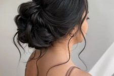 a modern elegant twisted low updo on long hair, with a bump on top and some locks down is a lovely and pretty idea