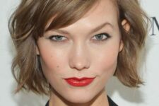 a mousy brown jaw-length bob with side bangs and messy waves is a lovely solution with effortless chic