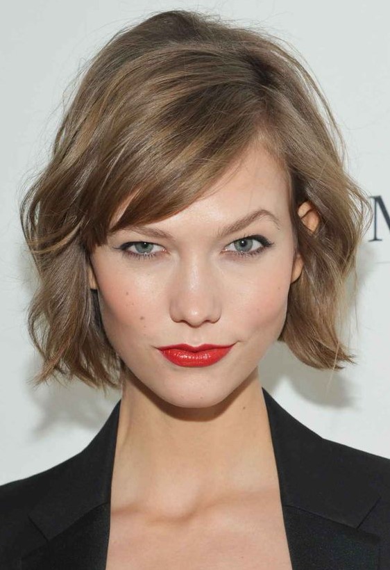 a mousy brown jaw-length bob with side bangs and messy waves is a lovely solution with effortless chic